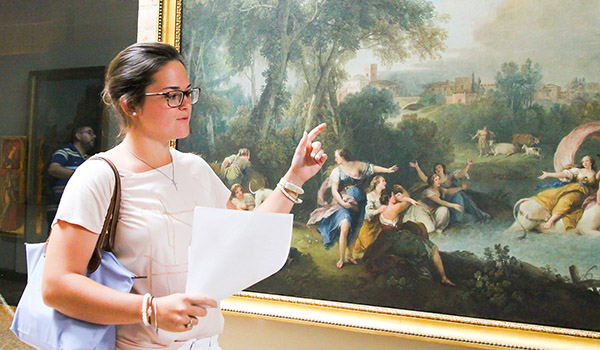 51̳ University students explaining a painting.